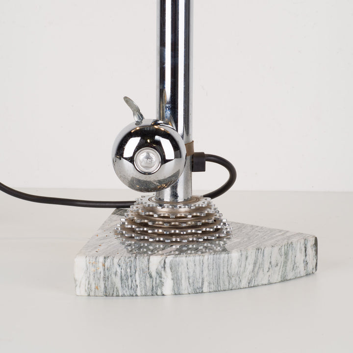 Fun metal table lamp with bicycle bell on a marble base.