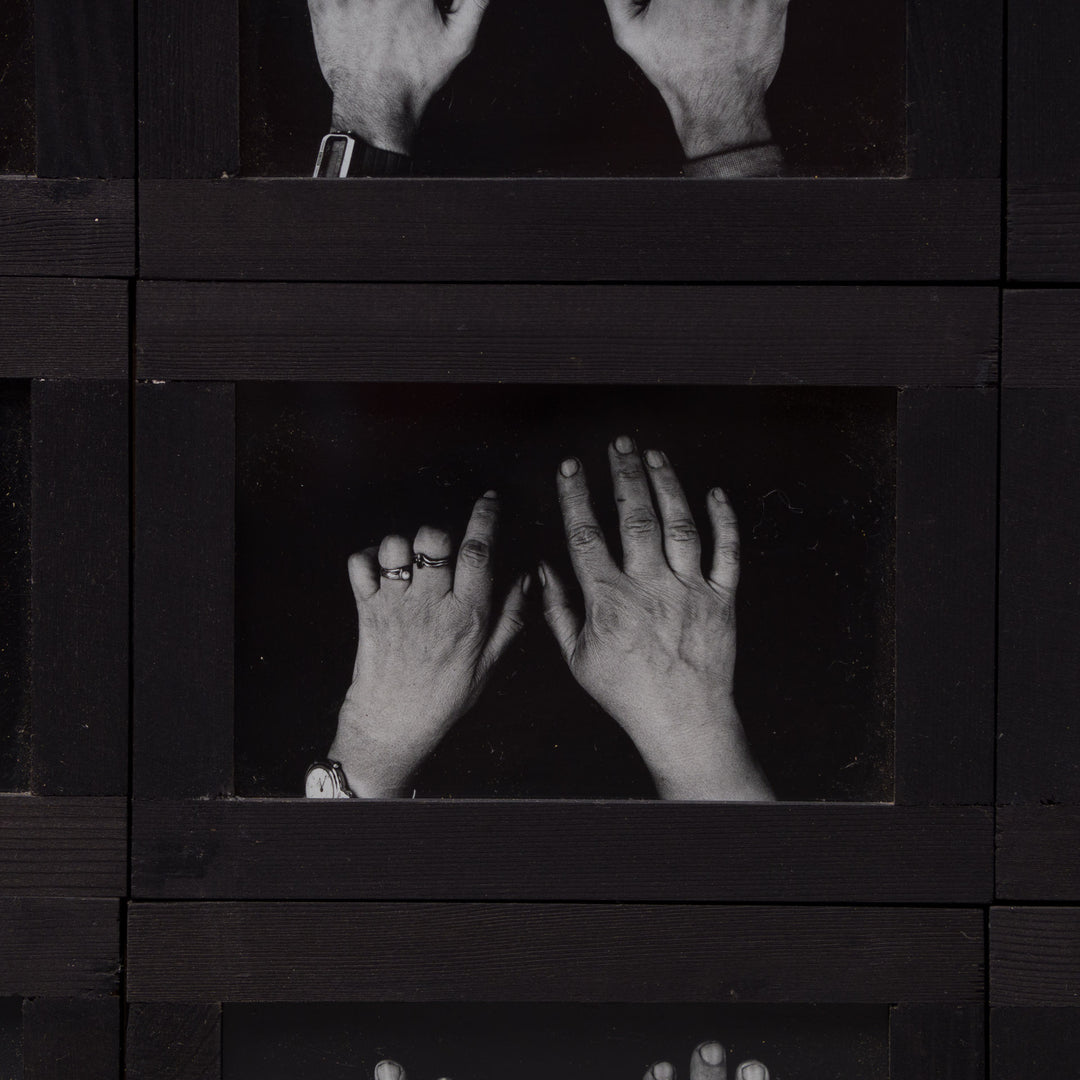 Grote zwarte houten fotokader met kunstzinnige foto's met handen
