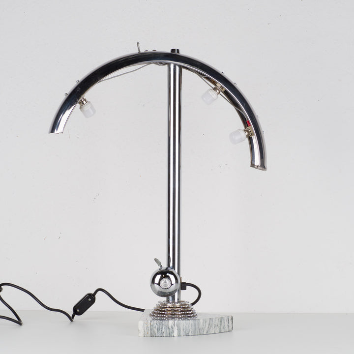 Fun metal table lamp with bicycle bell on a marble base.