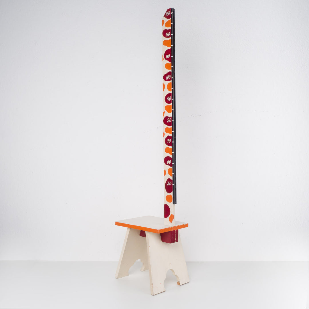 Fun wooden stool with a measuring stick in orange