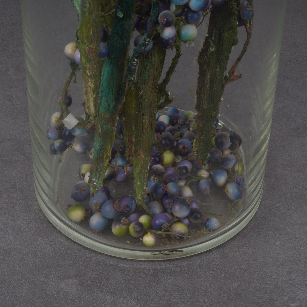 Large glass vase with beautiful branches of fake eucalyptus fruits in blue and green