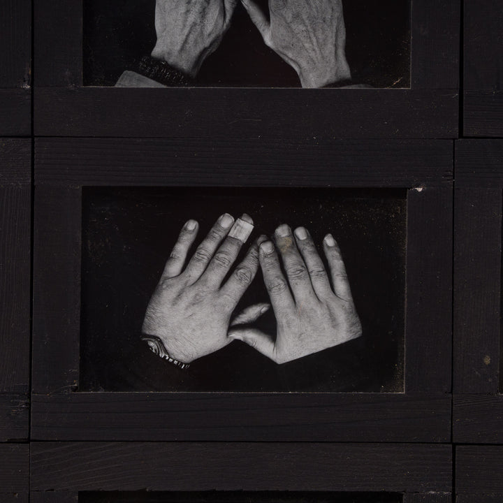 Grote zwarte houten fotokader met kunstzinnige foto's met handen
