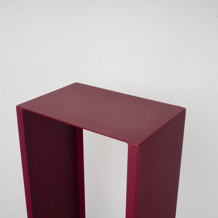 Elongated hollow metal base in burgundy red