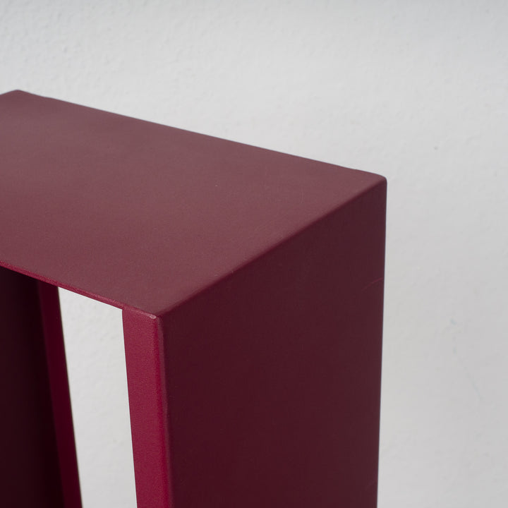 Elongated hollow metal base in burgundy red