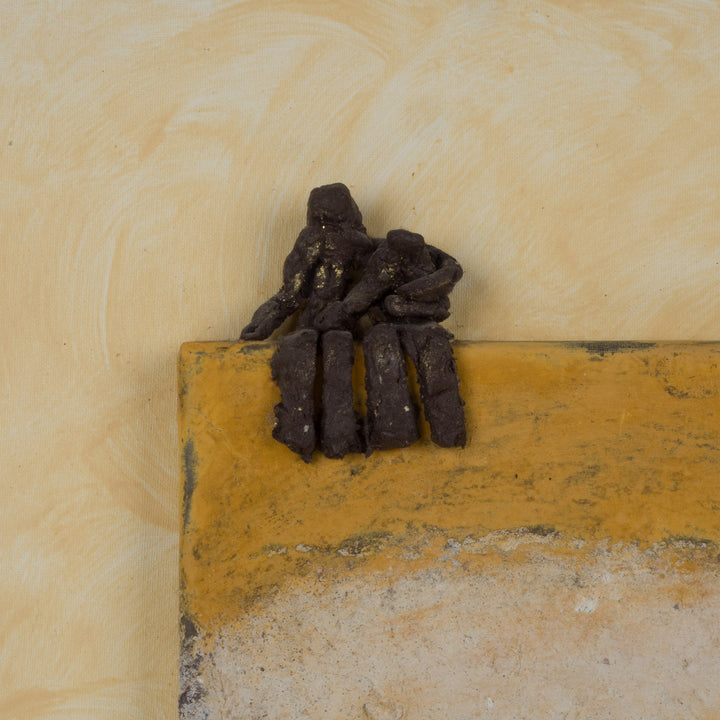 Schilderij in okergeel met 3D beeldje van zittende figuren – 40x40 cm